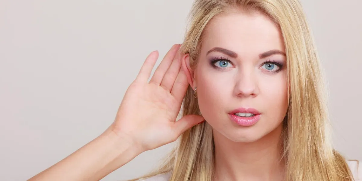 femme main à oreille écoute sur gossip gris fille avec paume derrière l'oreille espionnage closeup jeune entreprise femme écoute secret