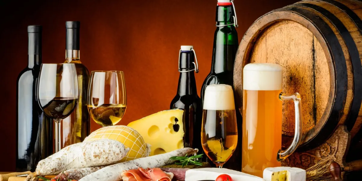 still life with wine, beer, traditional food, cheese and sausages