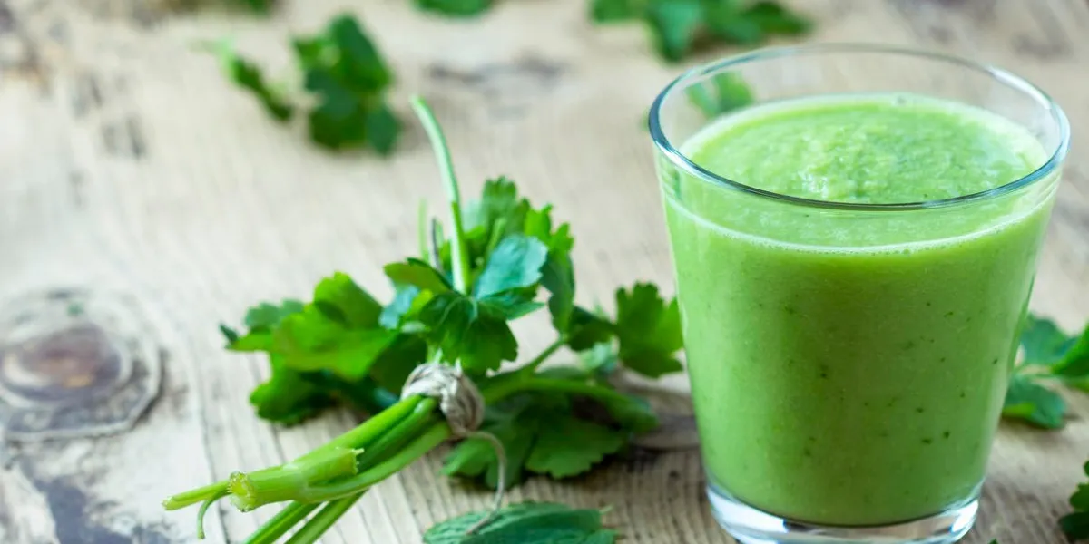 smoothie vert avec du persil sur une table en bois
