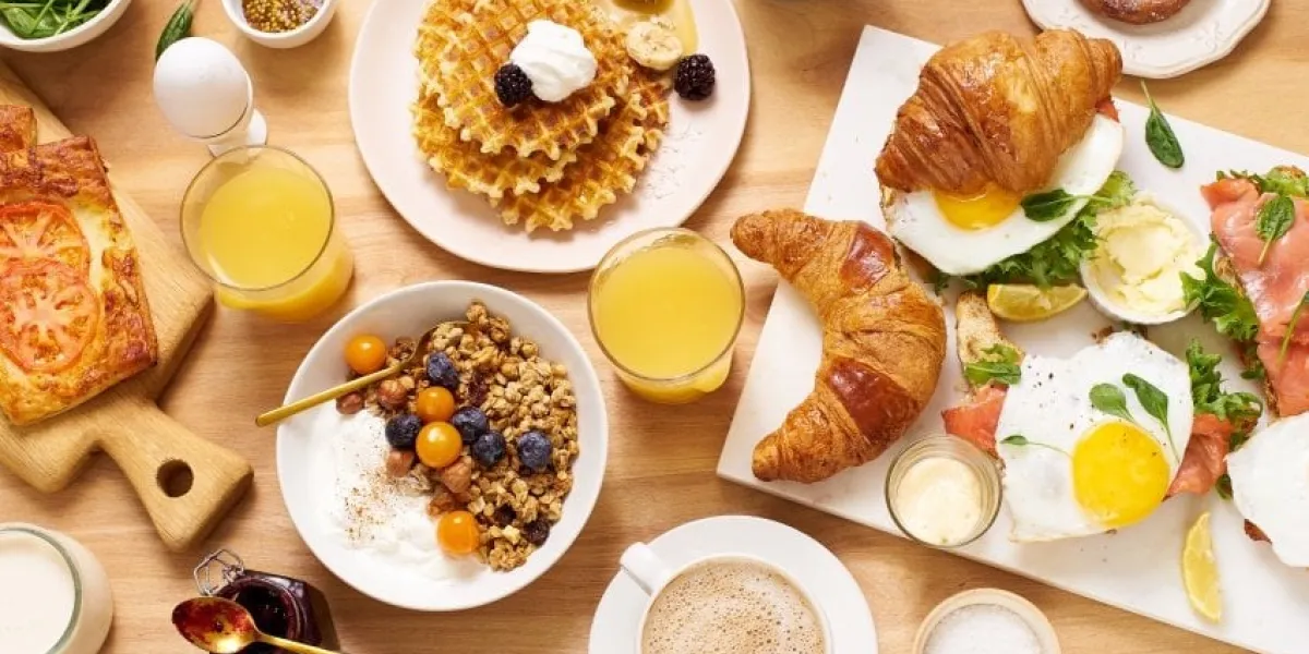 top view image of brunch menu on wooden table healthy sunday breakfast with croissants, waffles, granola and sandwiches flatlay with tasty food