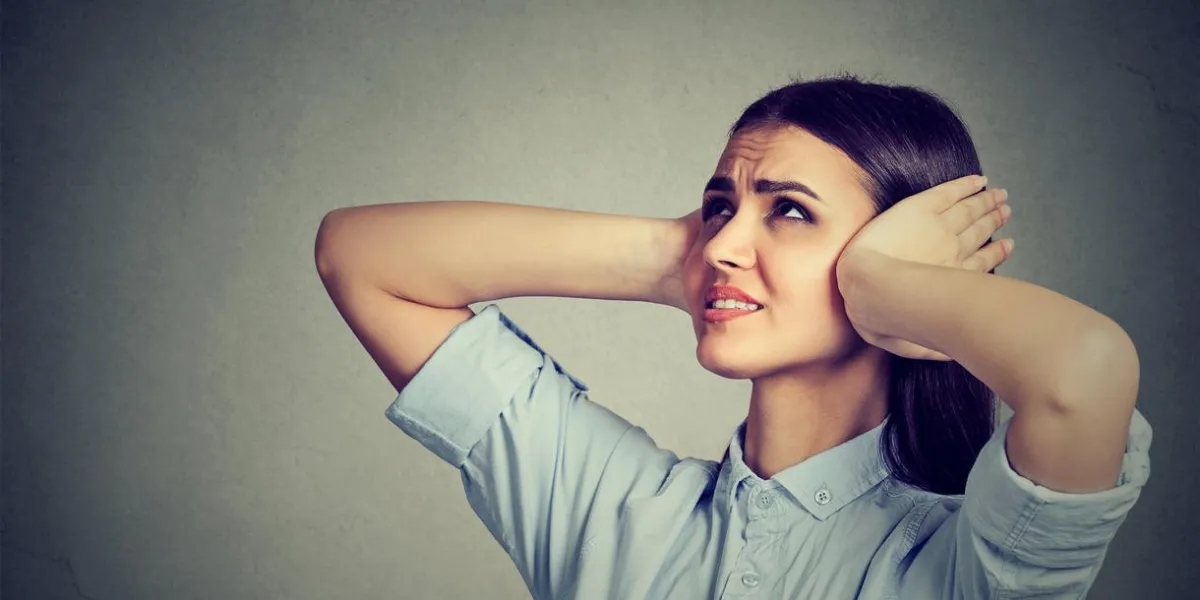 stressed frustrated woman covering her ears with hands