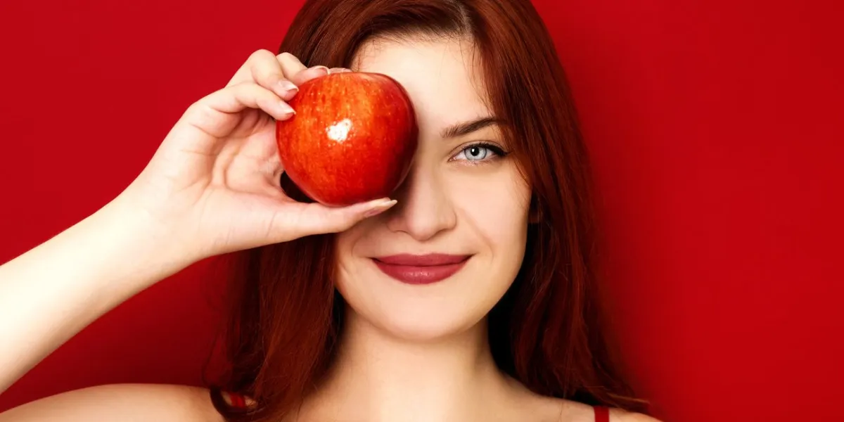 young smiling woman holding apple