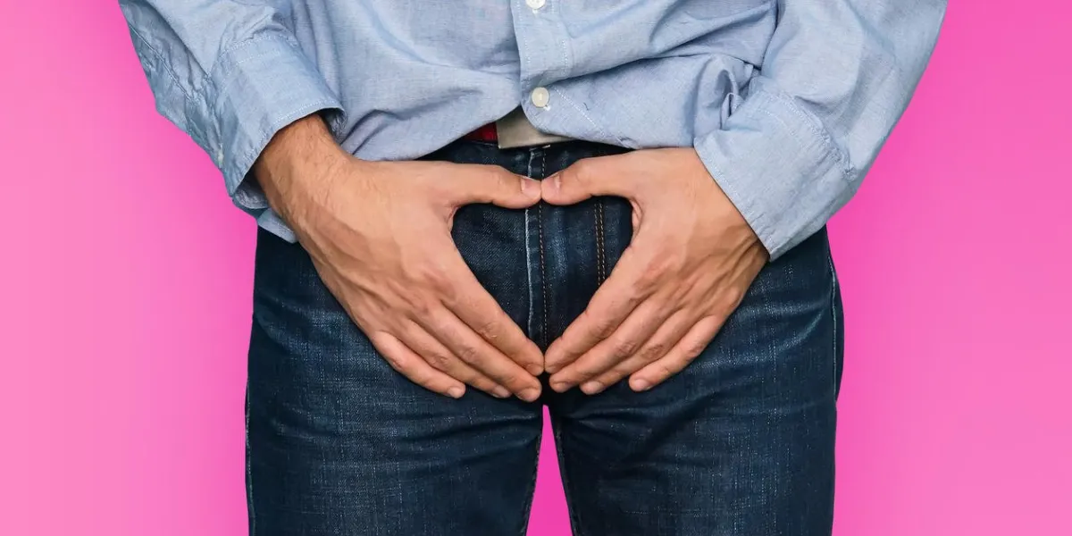 the guy has his hands on the testicles with folded hands in the shape of a heart on a pink background a symbol of love and sexuality
