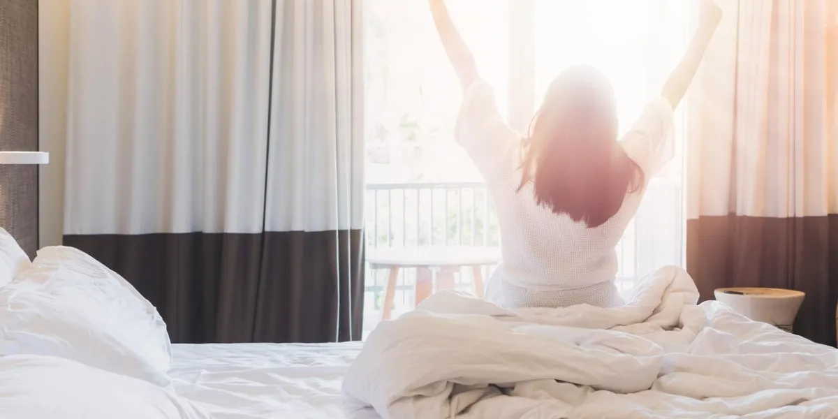 asian women are staying in a hotel room after wake up on morning open the curtain in the room looking to outside viewvintage tone