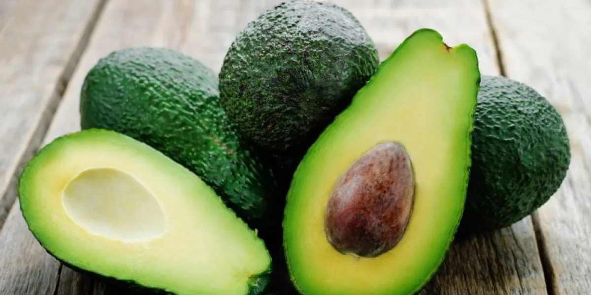 avocado on a dark wood background tinting selective focus