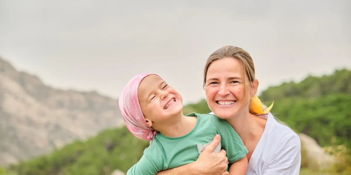 nurse plays with her young cancer patient in the wilderness concept of overcoming the disease