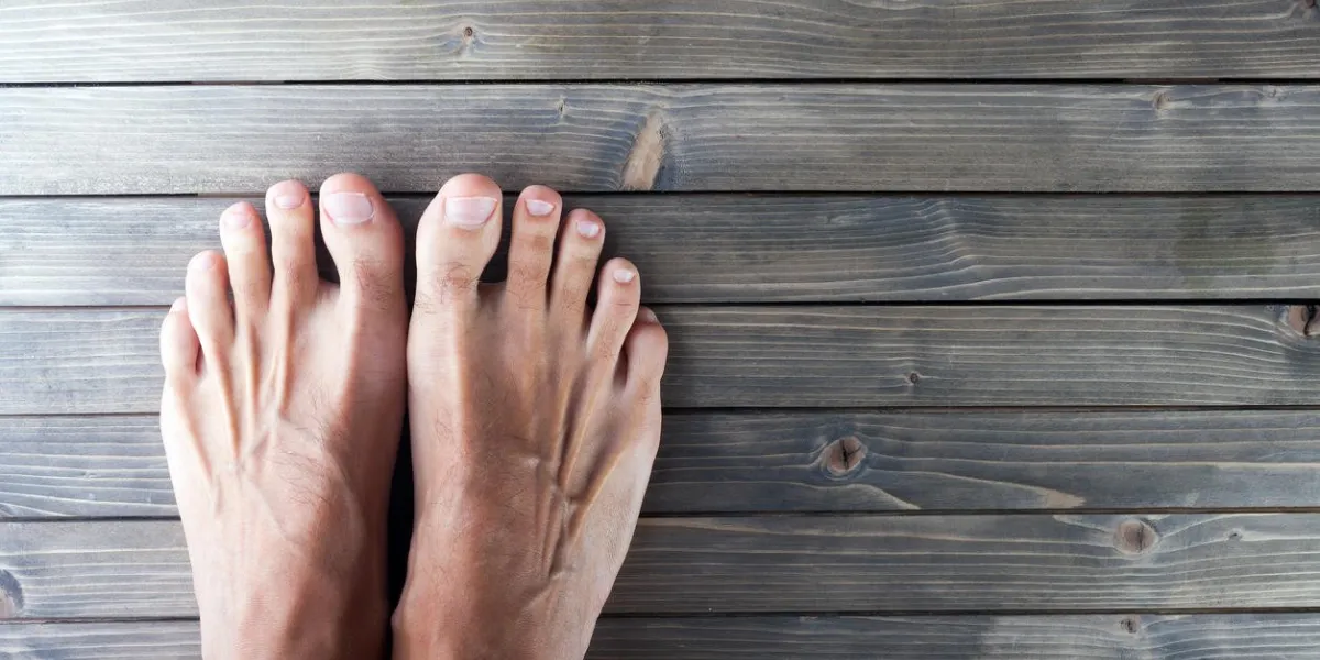 male feet on wooden background
