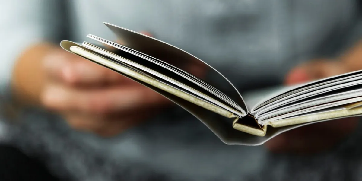 young women reading a small book