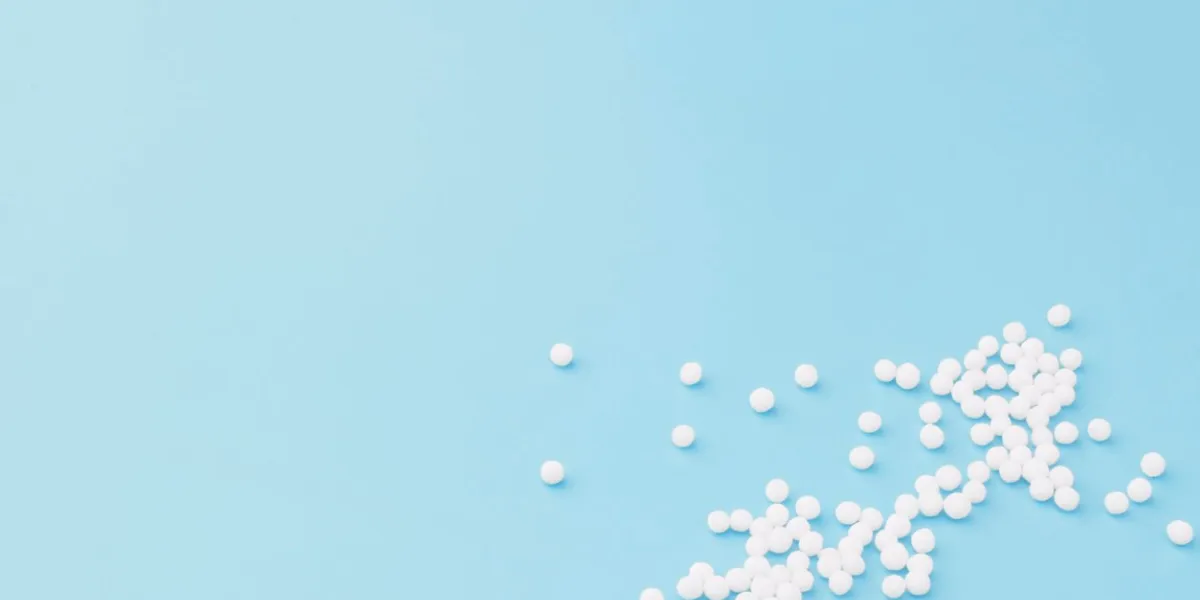 homeopathic globules scattered on a blue background alternative homeopathy medicine herbs, health care and pills concept flatlay top view copy space