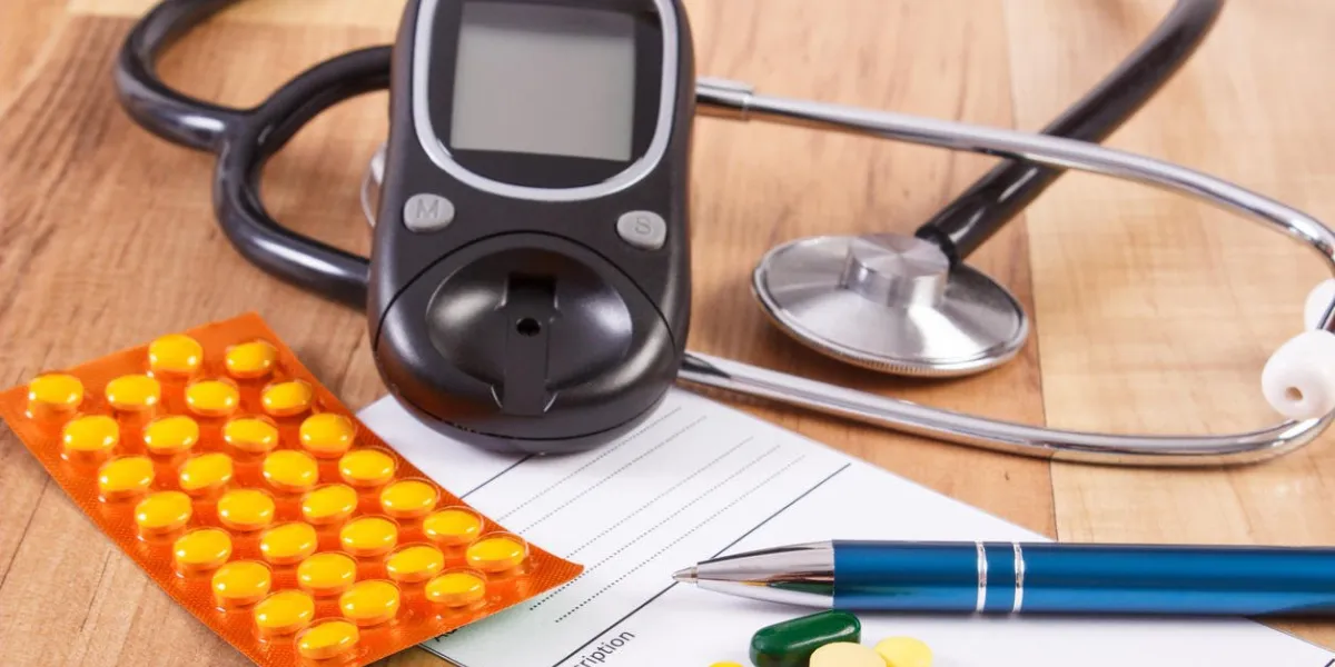 pilules médicales, des comprimés ou des suppléments pour la thérapie, la prescription, le lecteur de glycémie et le stéthoscope sur le bureau dans le bureau du médecin, le concept du diabète, le traitement et les soins de santé