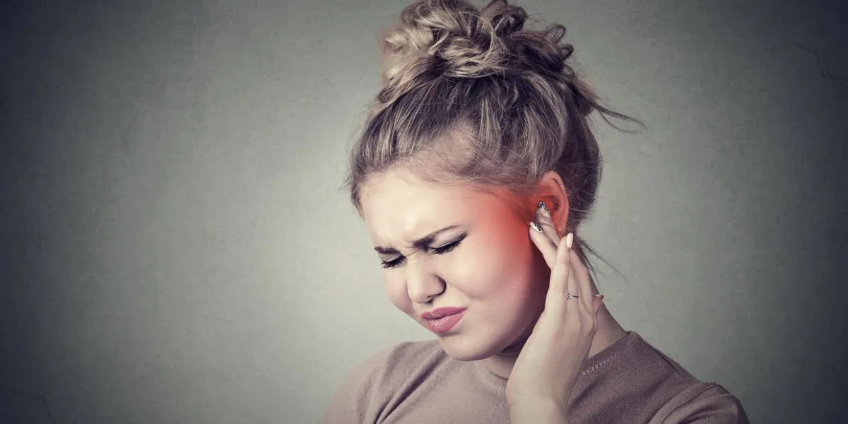 acouphène closeup up côté profil malade femelle ayant oreille douleur toucher sa tête douloureuse coloré en rouge isolé sur fond gris