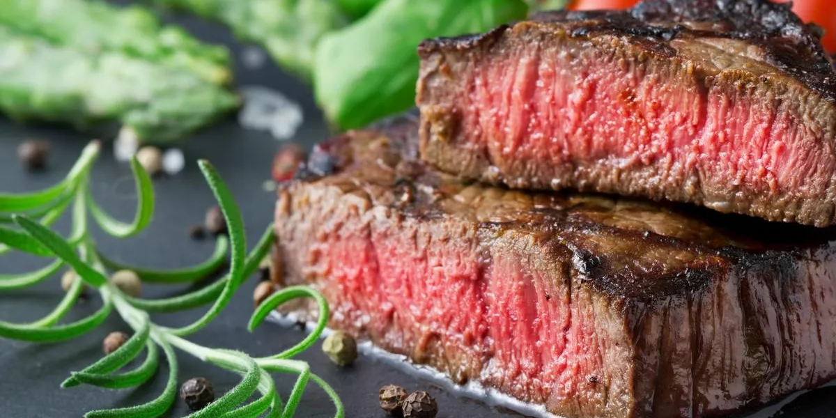 steak grillé moyen avec asperges et tomates sur une plaque d'ardoise