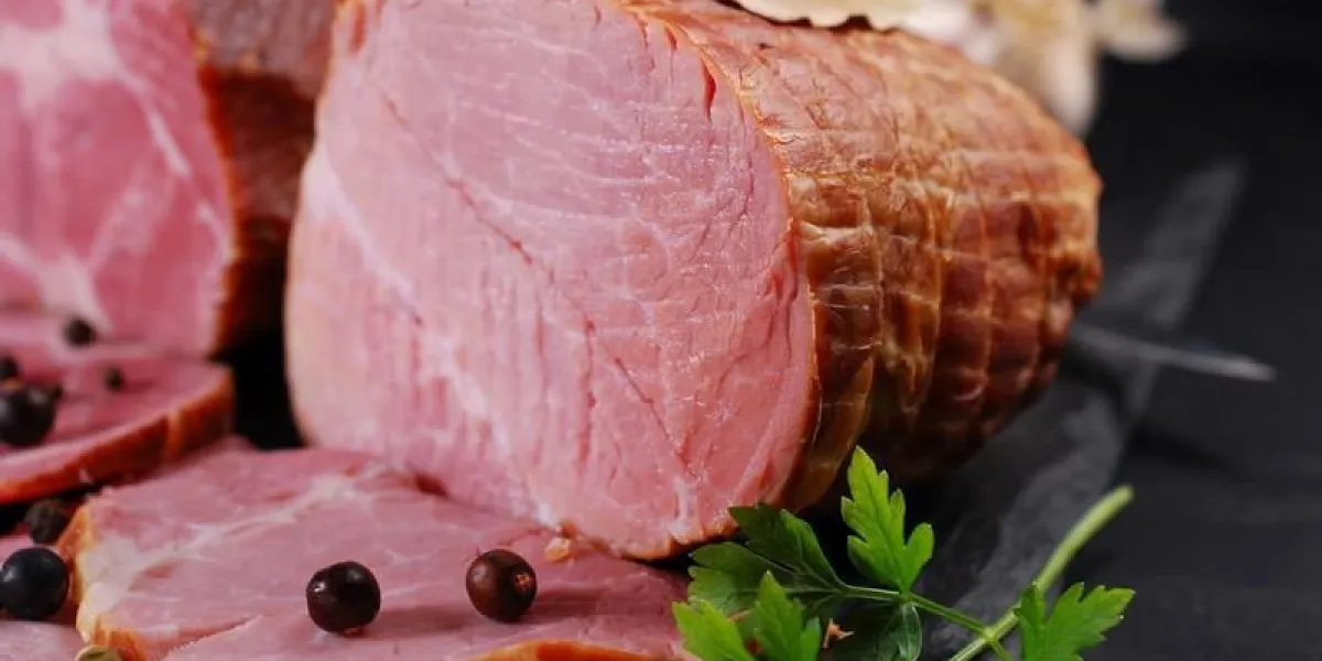 morceaux de délicieux jambon de porc fumé maison avec des épices sur fond noir