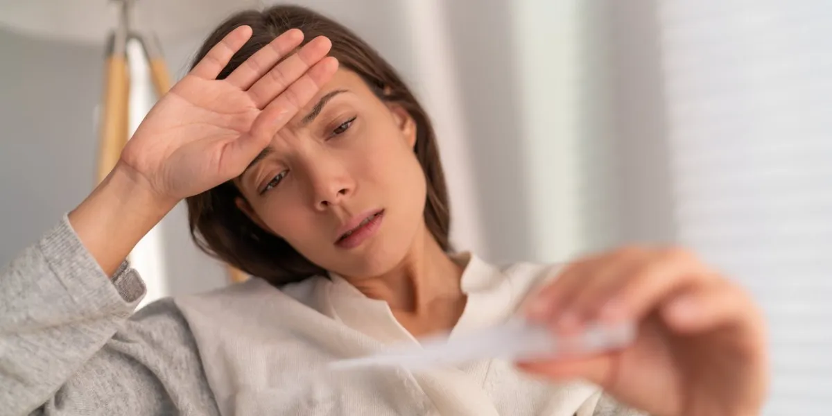 coronavirus asian woman checking temperature with thermometer the corona virus causes respiratory illness (like the flu) with symptoms such as a cough, high fever and in more severe cases, pneumonia