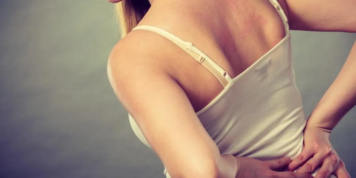 longues heures de travail et santé jeune femme avec mal de dos femme souffrant de maux de dos sur gris