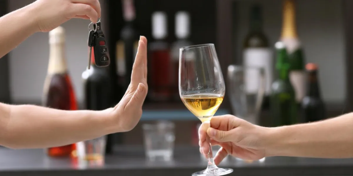 femme avec clé de voiture refusant le verre de boisson alcoolisée, sur fond flou ne pas boire et conduire le concept
