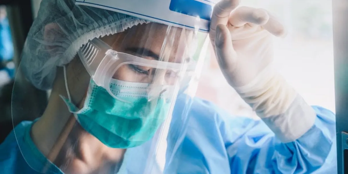 nurse having headache and tired from work while wearing ppe suit for protect coronavirus disease