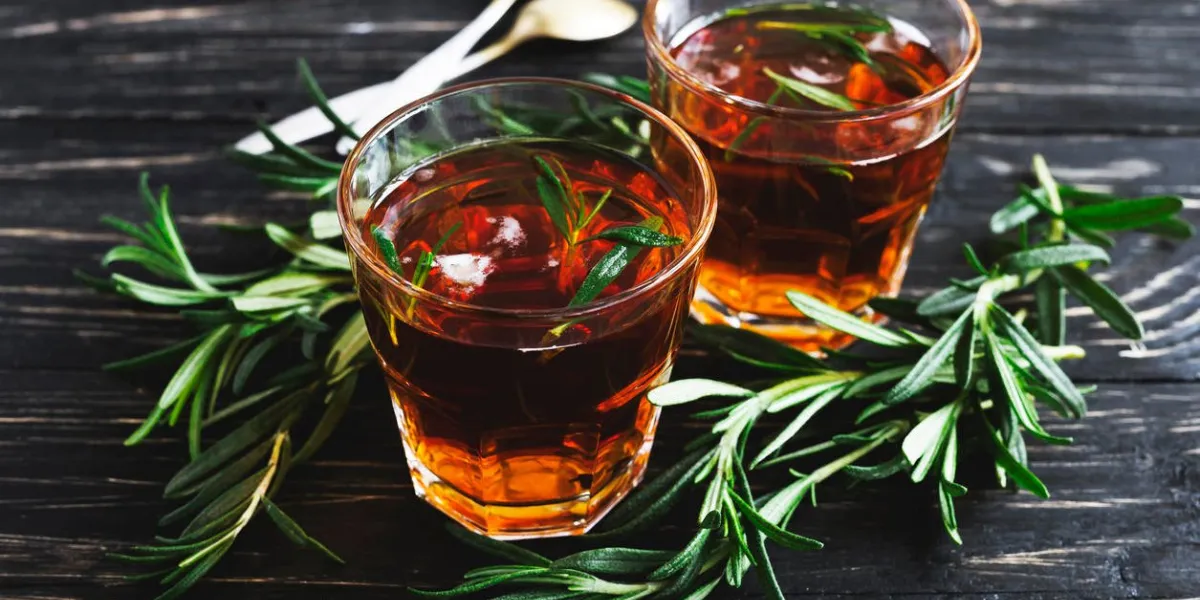 thé de romarin froid avec de la glace sur des boissons chaudes de table en bois