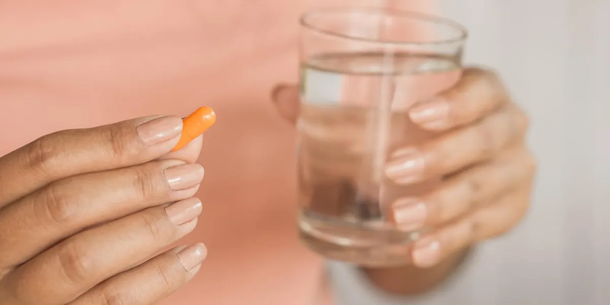 woman hand taking pill and glass of water in hand ,healthcare and medical