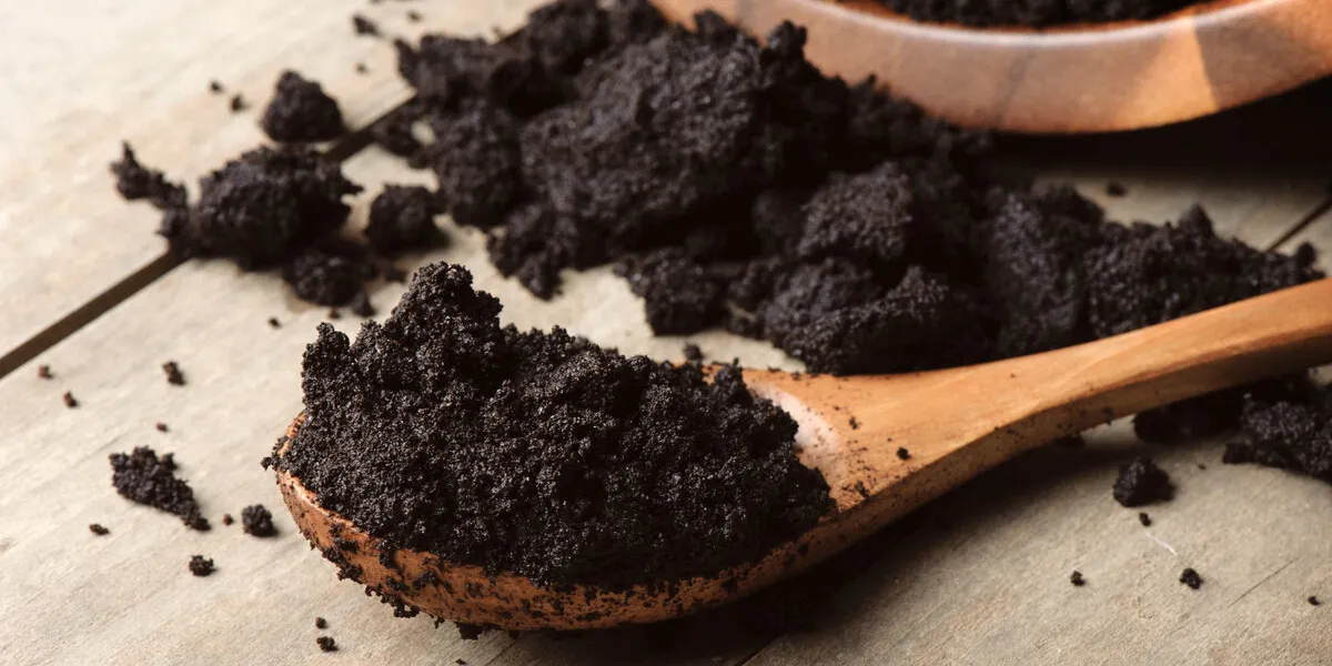 closeup detail of coffee ground in wooden spoon