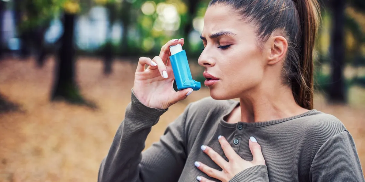 young woman treating asthma with inhaler