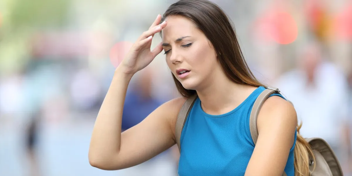single woman suffering headache outdoors in the street