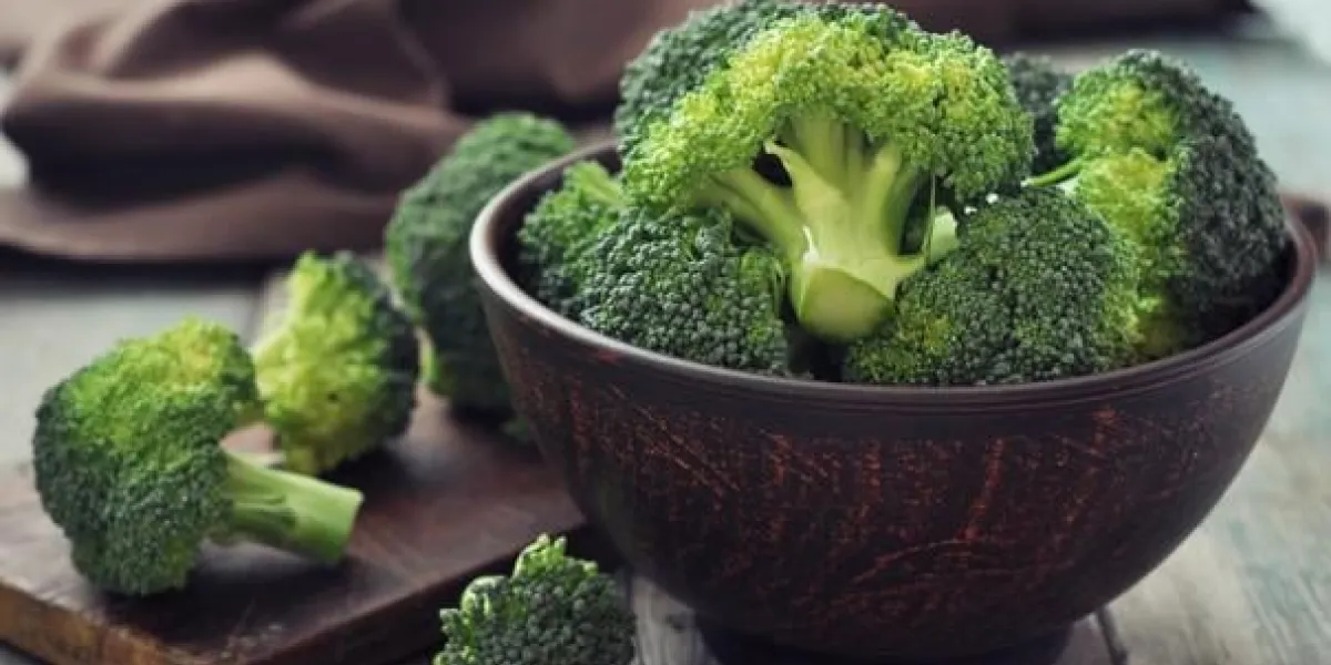 bouquet de brocoli vert frais dans un bol brun sur fond en bois