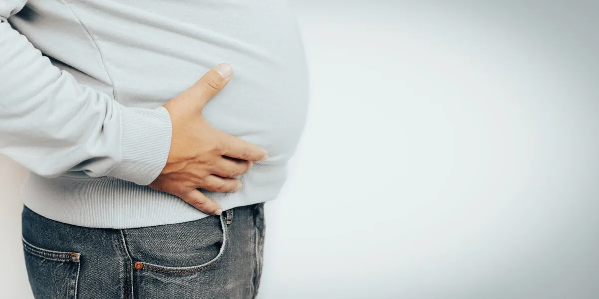 fat man suffering from stomach pain, ulcer discomfort, metabolic disorder or other health problem