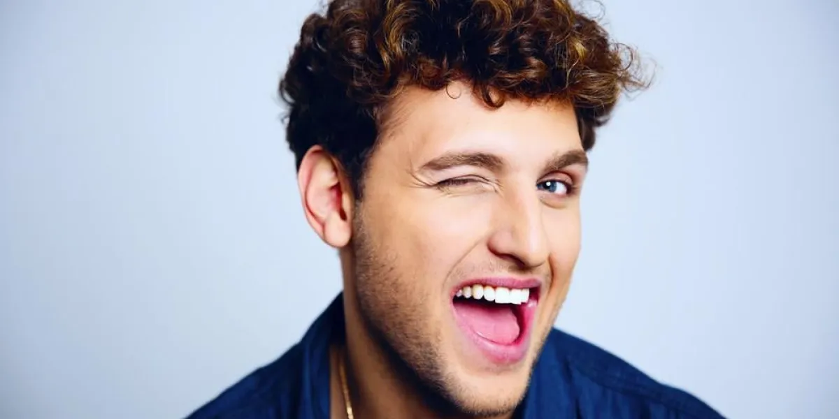 joyeux jeune homme un clin de œil sur fond bleu