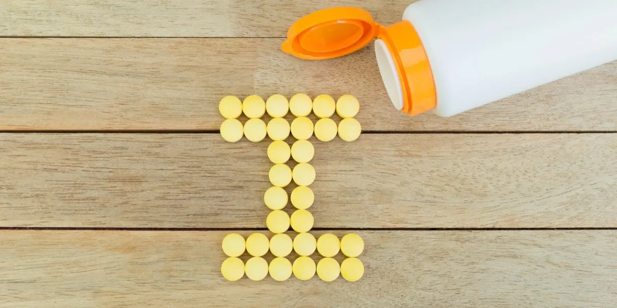 pilules jaunes formant la forme à i alphabet sur fond de bois