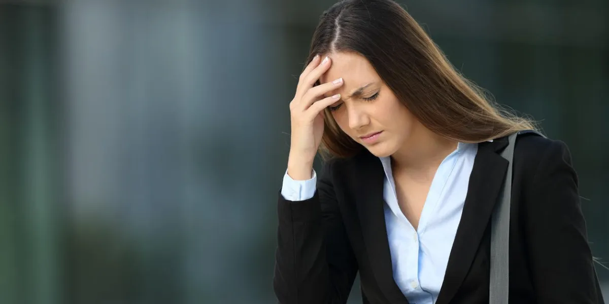 single executive suffering headache walking outside on the street