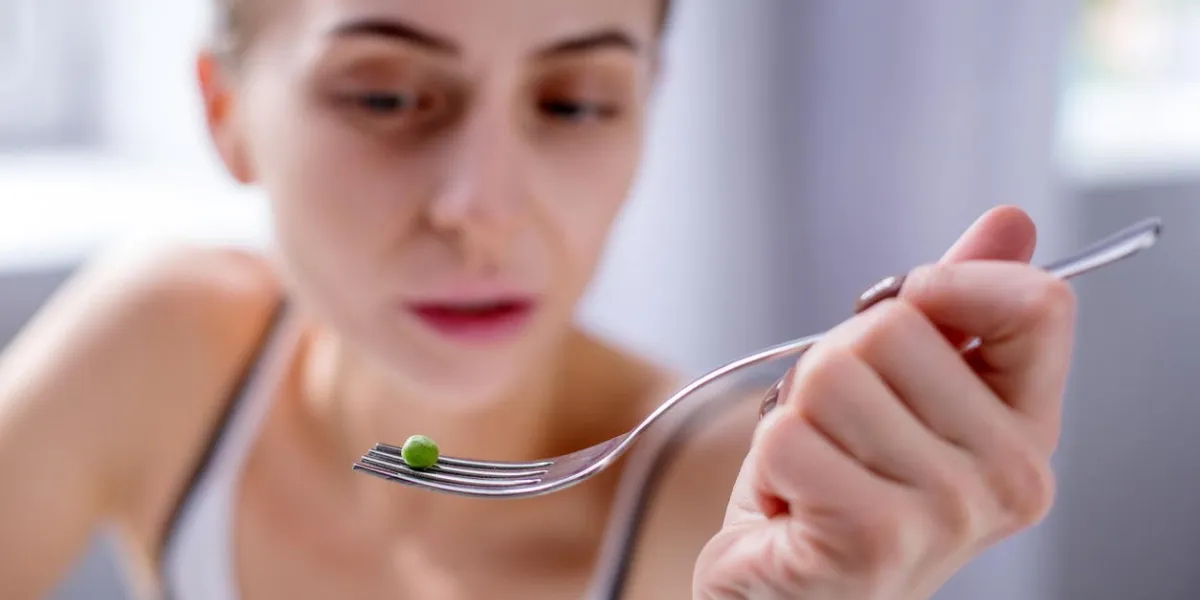 small portion selective focus of a fork with one pea lying on it