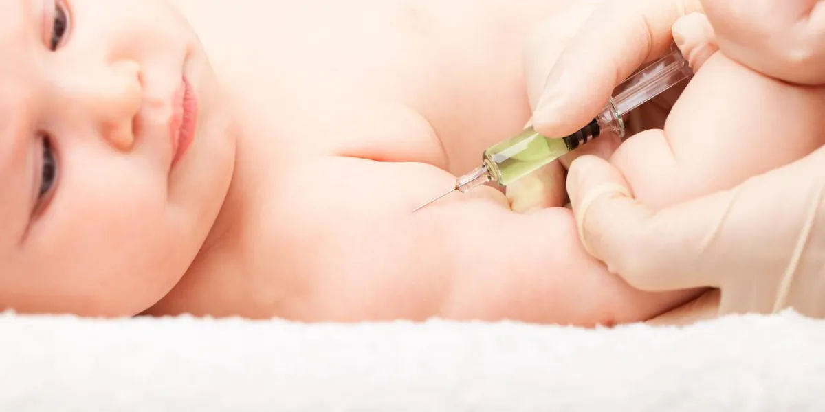 close-up shot of pediatrician giving a three month baby girl intramuscular injection in arm