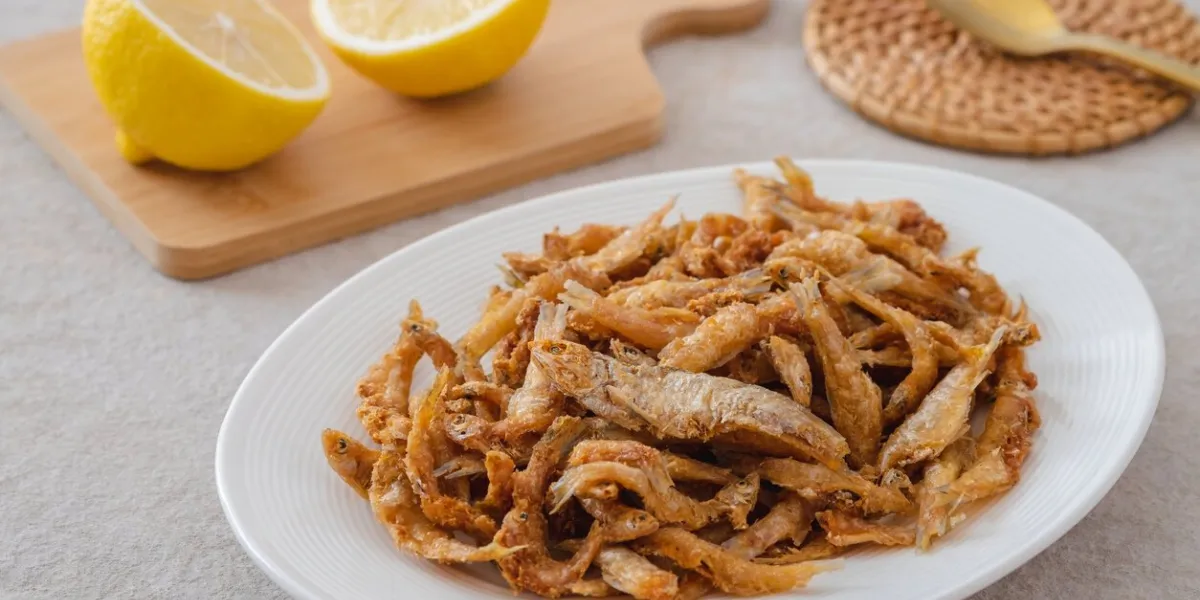 crispy fried small fish on white plate
