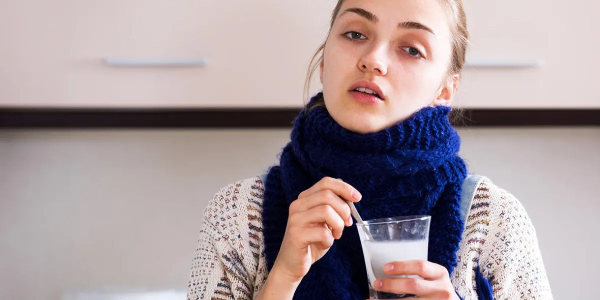 portrait jeune fille avec quinsy prenant des médicaments et gargariser la gorge dans la cuisine