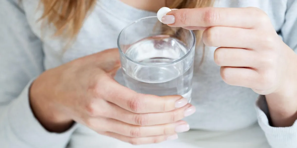 horizontal view of ill woman taking aspirin