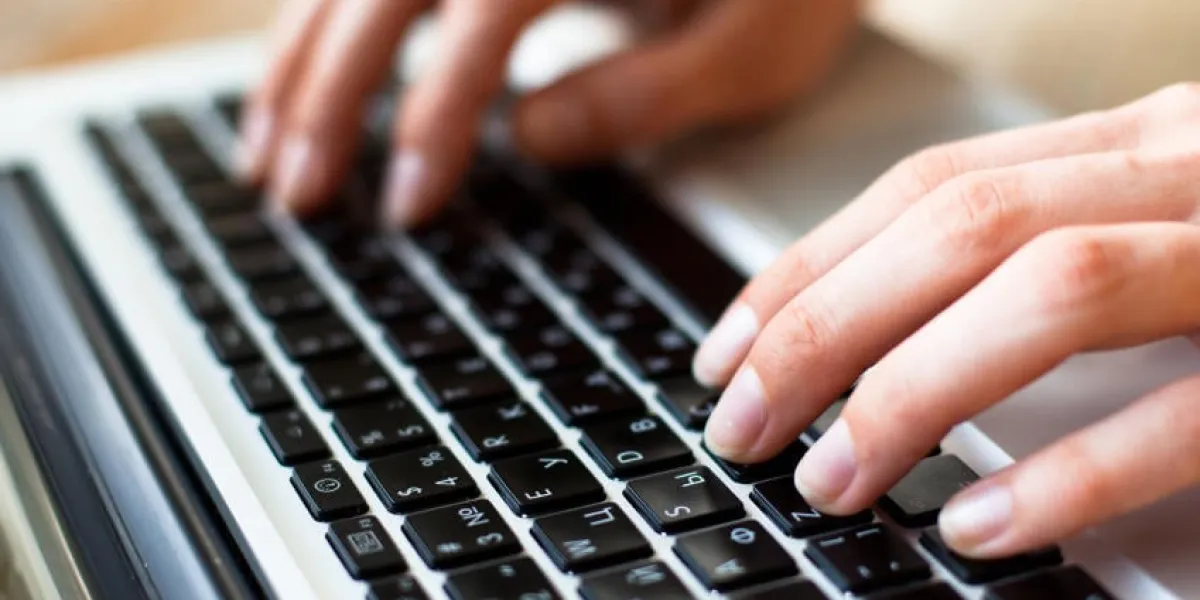 photo de mains tapant du texte sur un clavier d'ordinateur portable