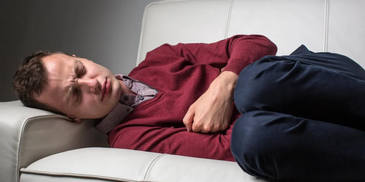 young man suffering from severe belly pain, being cornered by the debilitating condition of celiac disease crohn's disease