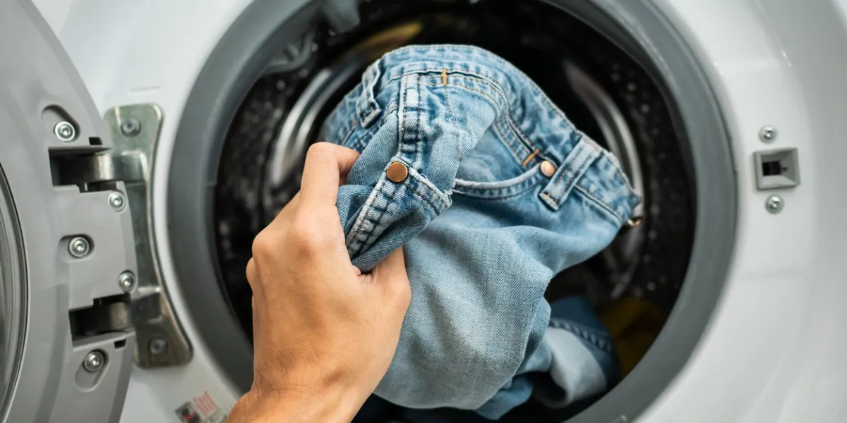 putting jeans into the washing machine