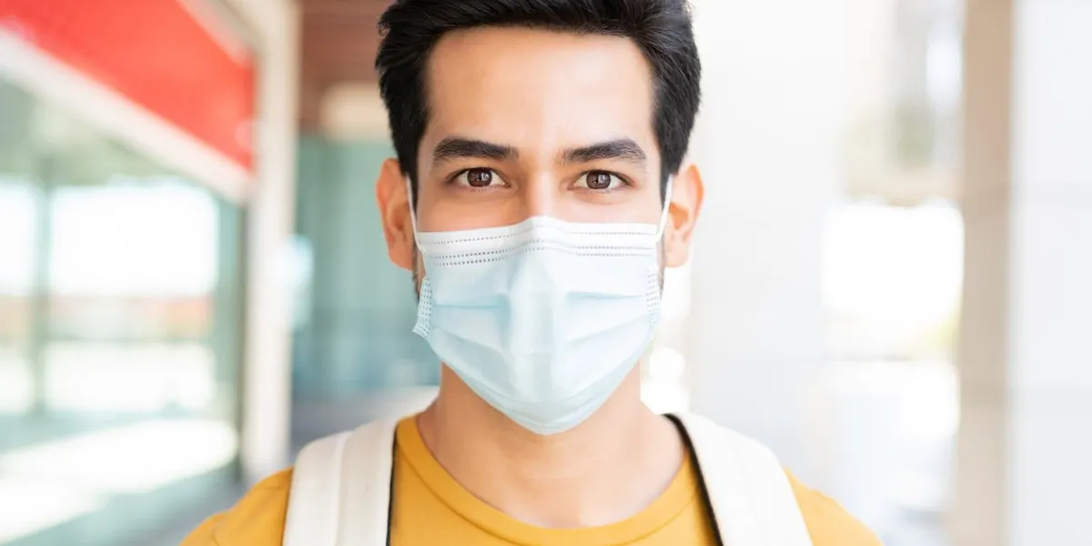 closeup portrait of young man wearing face mask during coronavirus crisis in city