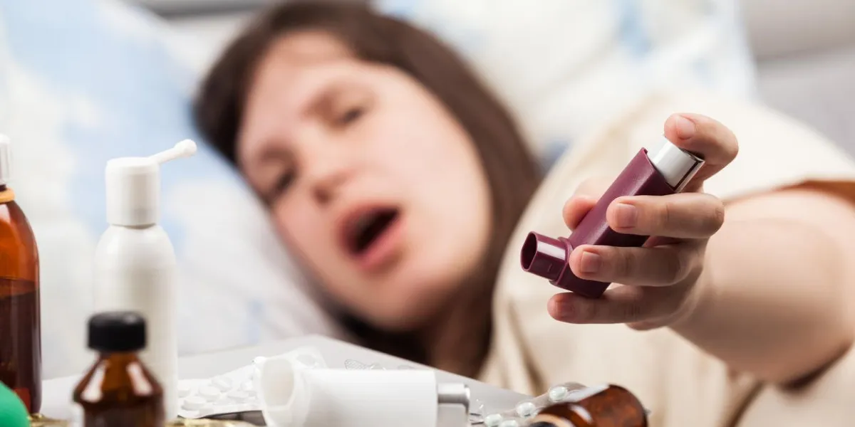 adult woman patient lying down bed hand holding medical asthmatic inhaler for asthma or allergy illness relief
