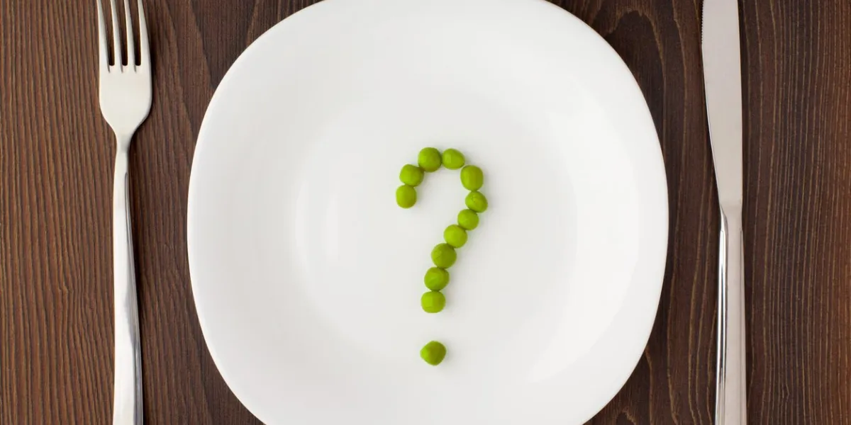 question mark made of peas on a white plate