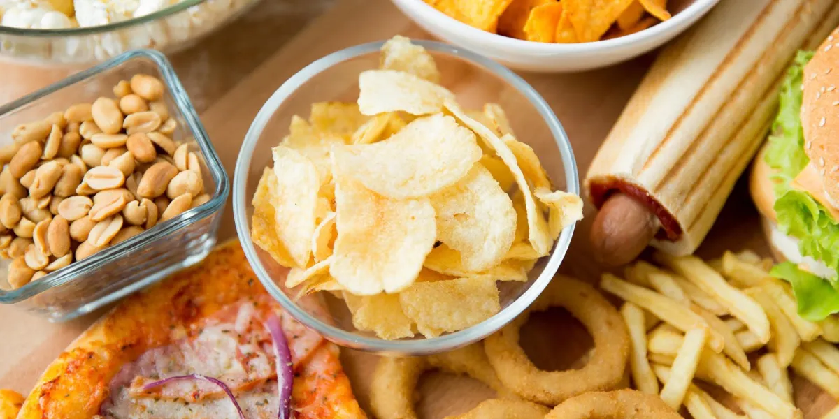 restauration rapide et concept de mauvaise alimentation - gros plan de différentes collations de restauration rapide sur la table en bois