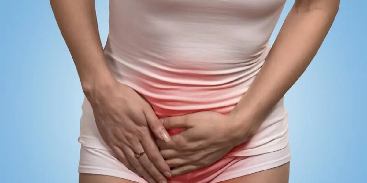 gros plan image recadrée d'une femme avec les mains tenant son entrejambe bas de l'abdomen isolé sur fond bleu