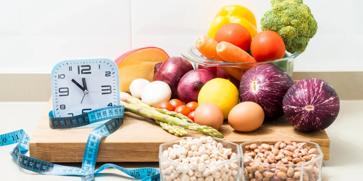 still life with a clock, a tape measure and healthy food conceptual image of intermittent fasting, a diet with benefits such as the regenerative mechanism of autophagy