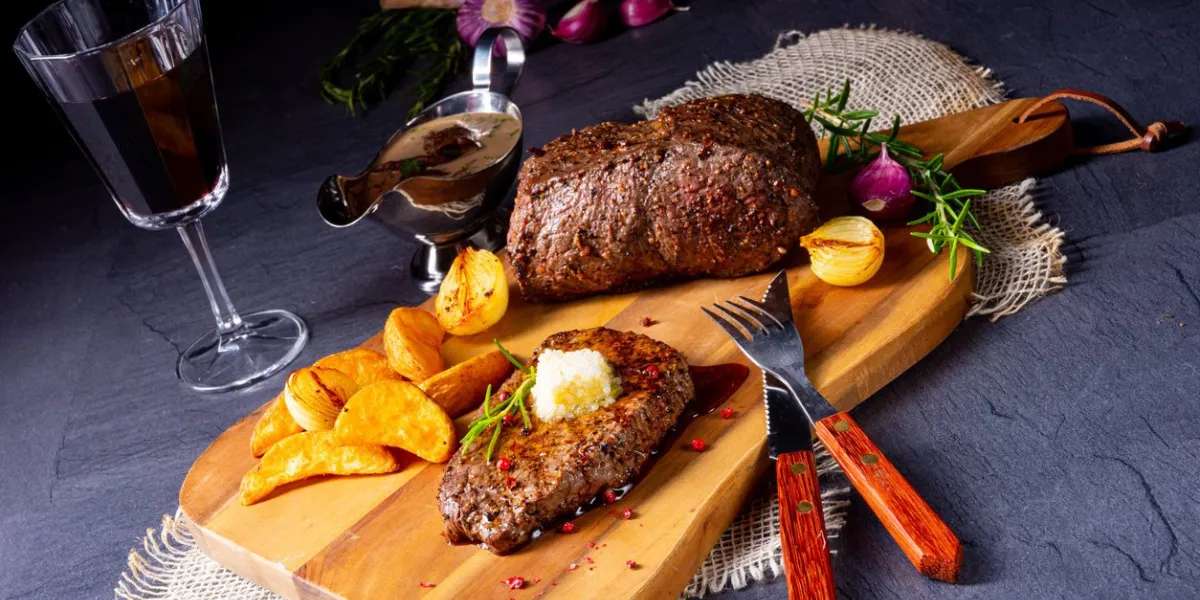 butter beef steak with herbs and potato wedges