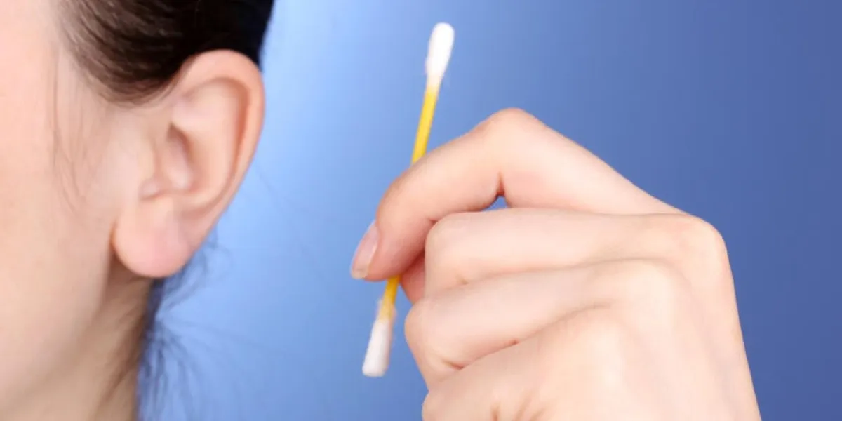 oreille humaine et cotons-tiges close-up sur fond bleu