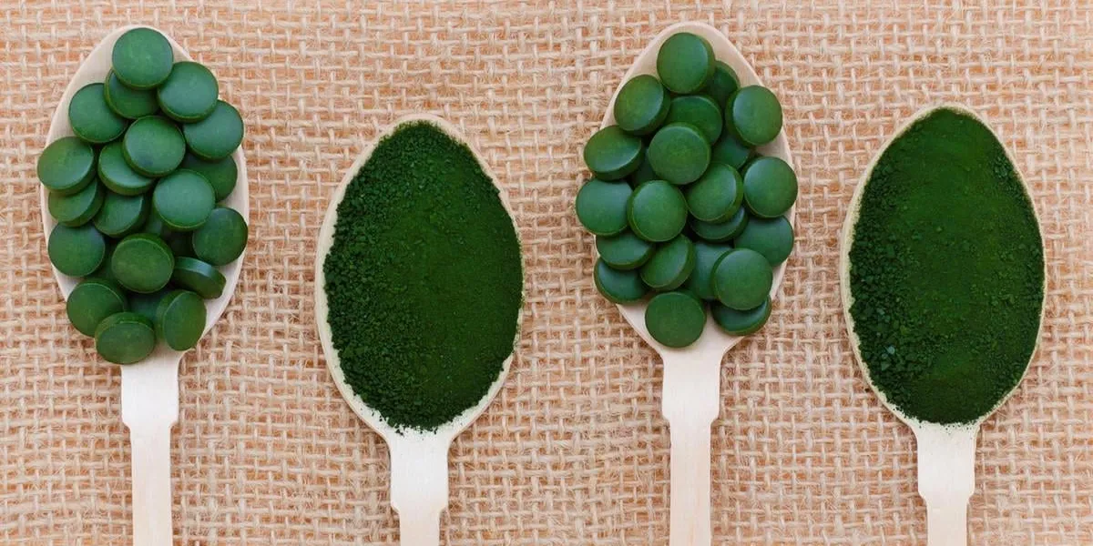healthy lifestyle, superfood, seaweed, spirulina and chlorella pills and powder in wooden spoons