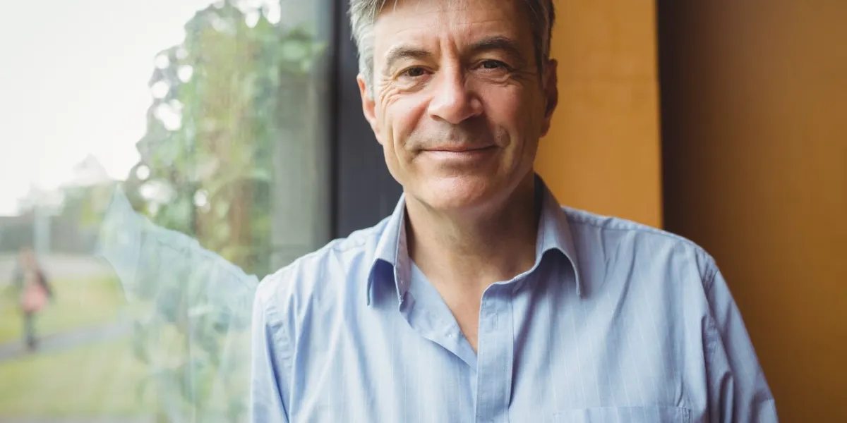 portrait of professor standing near window in college