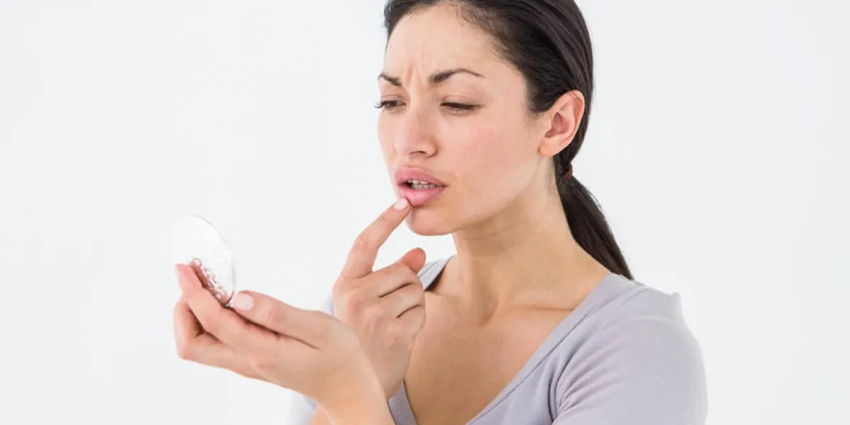 femme inquiète en regardant ses lèvres sur fond blanc
